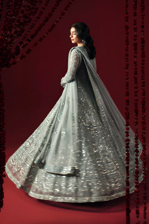 Side profile of NAQSHI Satayesh aqua dress showing full panel flare, embroidery and sequin sleeve detail